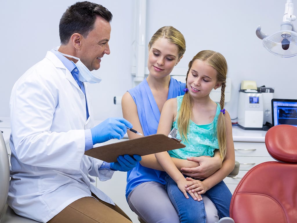 Woman with her child consulting with dentist