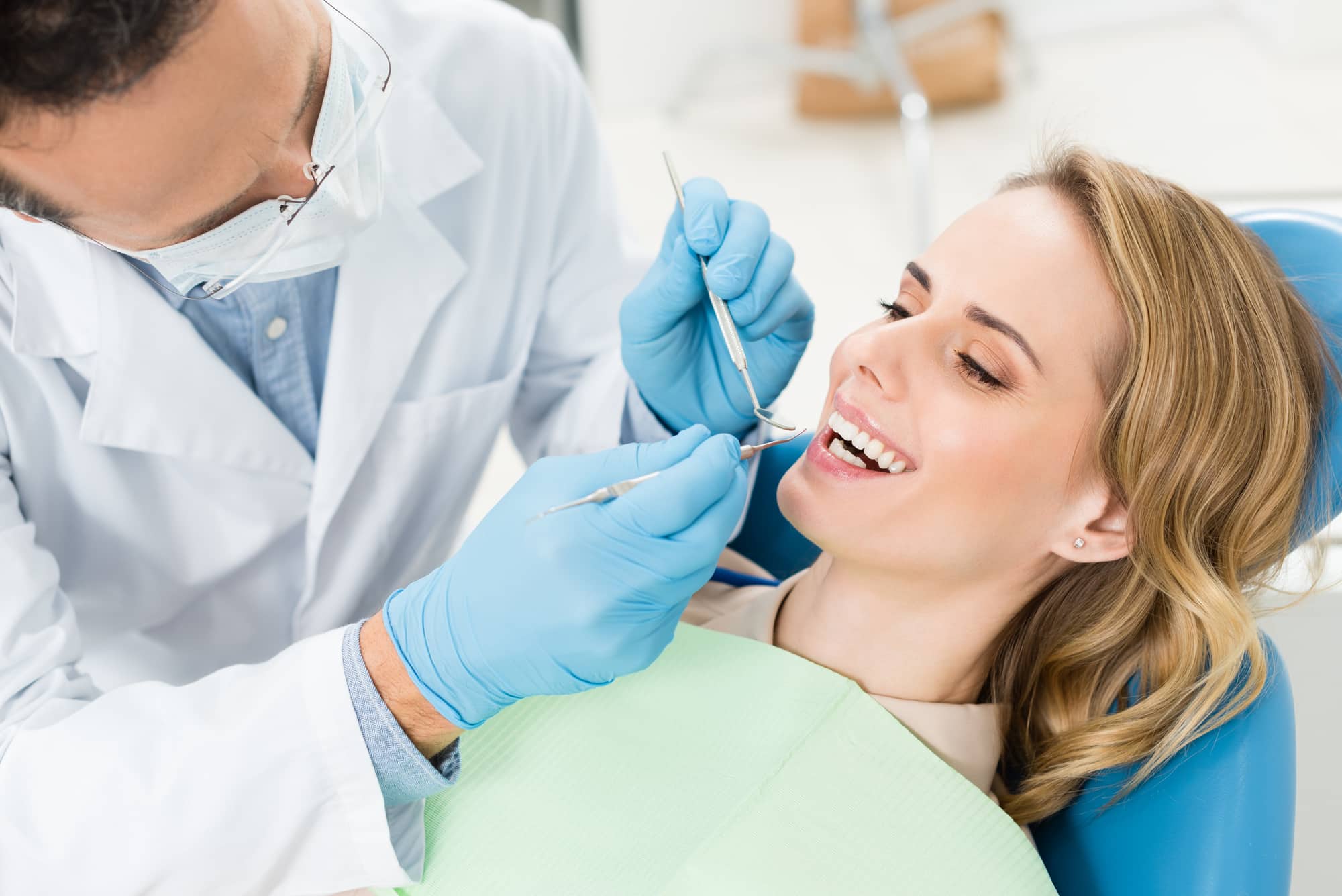 Doctor treats patient teeth in modern dental clinic