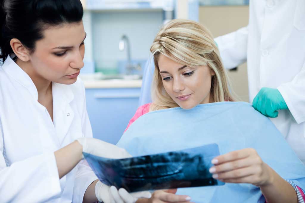 patient consulting dentist implant vs bridge